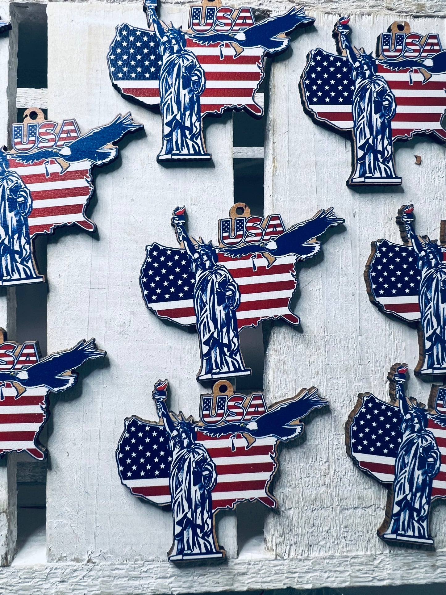 Wood cut USA shape with American flag print on it and Statue of Liberty.